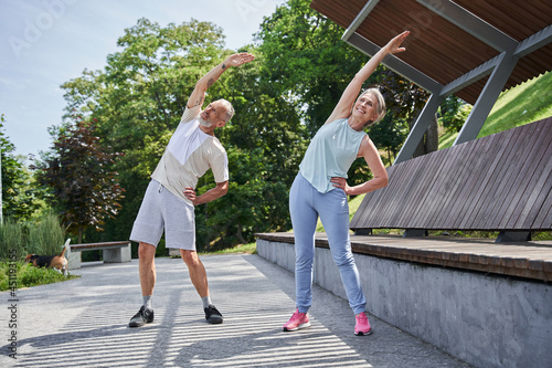 Senior couple training together at the summer park and feeling healthy