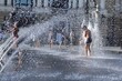 Children bathe in jets of fountain in the city square
