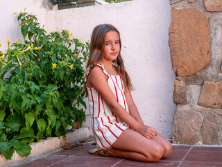 cute caucasian girl sitting on the floor in a garden