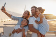 © Yaroslav Astakhov - Happy tourists, beautiful family taking selfie while standing together outdoors ready for boarding the plane at sunset. Vacation, parenthood, traveling concept