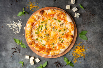 Delicious Italian 4 cheese pizza on dark background. With ingredients. Traditional Italian food. Top view.