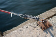 Parking the yacht to pier with mooring spring on rusty metal ring