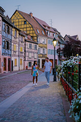 Wall Mural - Colmar, Alsace, France. Petite Venice, water canal, and traditional half timbered houses. Colmar is a charming town in Alsace, France. couple man and women walking at the street during vacation