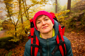 Wall Mural - The woman hiker travels in the woods is looking around