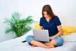 © ADDICTIVE STOCK - Happy woman working on laptop at home