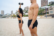 © ADDICTIVE STOCK - Diverse strong sportsman and sportswoman doing exercises with dumbbells on beach at