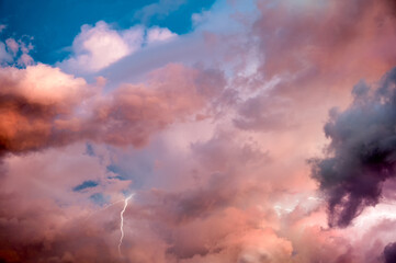 beautiful dramatic sky with colorful clouds and thunderbolt at sunset