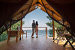 © pressmaster - Rear view of amorous couple standing close to each other and looking at blue ocean while enjoying summer vacation