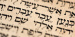 Closeup of hebrew words in Torah page that translate in english as Cursed be Canaan, a servant of servants shall he be to his brothers. Selective focus. Banner.