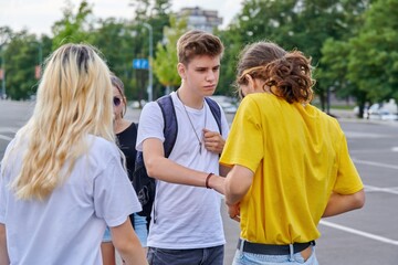 Wall Mural - Group of teenagers in city, serious guy talking to friend