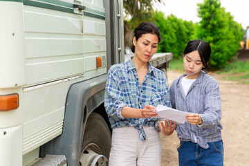 Farmer and freight forwarder sign documents for shipment in the courtyard