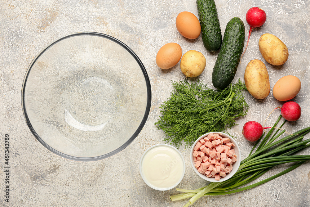 Glass bowl and ingredients for okroshka on light background