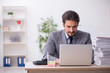 © Elnur - Young male employee and too much work in the office