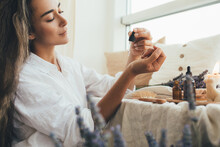 Young Woman Applying Natural Organic Essential Oil On Hair And Skin. Home Spa And Beauty Rituals.