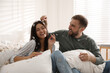 © New Africa - Happy young couple resting after fun pillow fight in bedroom