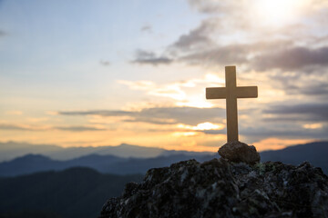 Jesus Christ cross. Easter, resurrection concept. Christian wooden cross on a background with dramatic lighting, colorful mountain sunset.