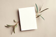 Greeting or invitation card mockup with eucalyptus twigs. Card mockup with copy space on beige paper background.