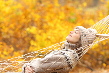 Wall Mural - Woman sleeping on hammock in a forest in autumn