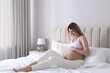 © New Africa - Beautiful pregnant woman sitting on bed at home