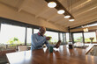 © Wavebreak Media - Happy senior african american man siting in the modern kitchen and making video call