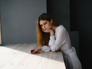 Canvas Print - woman with sad facial expression white dress near luxury window