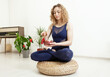 Woman yogi plays on Tibetan singing bowl. Young woman meditating in yoga studio. Yoga and healthy lifestyle concept