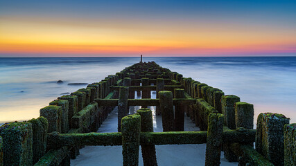 Wall Mural - Dusk at Breakwater in a stormy sea in summer