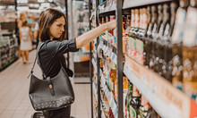 Young Woman Choosing Beer In A Supermarket