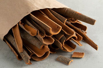 Wall Mural - Paper bag with dried cassia cinnamon bark pieces close up   