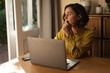 © Wavebreak Media - Caucasian woman in living room sitting at table, working using laptop