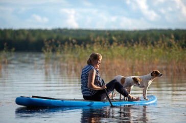 Wall Mural - Woman on paddle board with dog