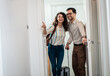 © Zoran Zeremski - Smiling couple with suitcase arriving in apartment.