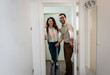 © Zoran Zeremski - Smiling couple with suitcase arriving in apartment.