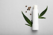 Hygienic hemp lipstick, green leaves and seeds on white background, flat lay with space for text. Natural cosmetics