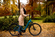 Young Woman With Electric Bicycle In Te Autumn Park