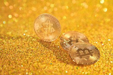 Three bitcoin coins. Cryptocurrency bitcoin is the coin of the future. Golden Bitcoin. Golden shiny background. High quality photo