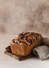 Wall Mural - Homemade spicy plum cake decorated with almond on a wooden serving board, concrete background. Loaf cake with plum, spices and almond.