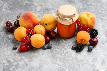 Wall Mural - Jar with peach jam and fresh fruits on stone background.