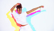 Dancing mixed race girl in colourful light on white studio background. Female dancer performer with afro hair dance