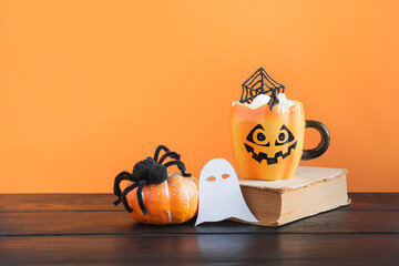 Wall Mural - Halloween cup of coffee garnish spider web, black spider, pumpkin. Holiday horror treat.