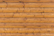 Wooden background. Texture of a brown wooden wall made of logs.