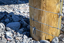 Close Up Of Components Of A Post And Netting Farm Fence Along The Border Of The Farm And River Bed, Canterbury, New Zealand