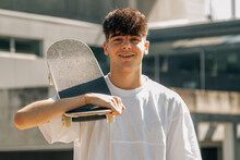 Portrait Of Teen Boy With Skateboard