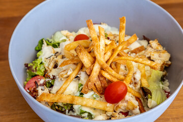 Closeup shot of a Cesar salad in a bowl on a table in a restaurant