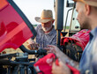 © Budimir Jevtic - Farmers working with wrench on broken tractor in field