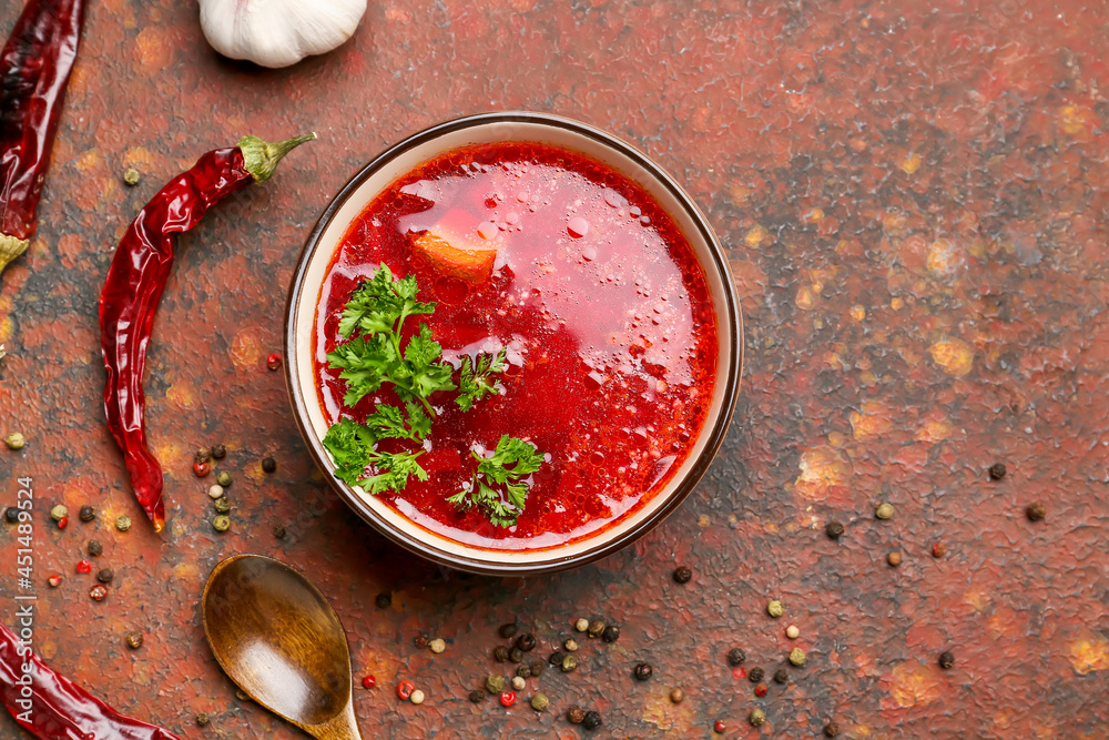 Bowl with tasty borscht on grunge background