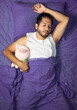 © Narayan - latin man sleeping in bed with pig stuffed animal, sleep concept
