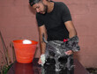© Narayan - Latin man bathing his adopted pet dog, dog care concept