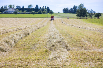 Canvas Print - Closeup of a farming machinery harvesting hay on the farm field