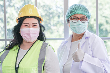 Wall Mural - Worker woman and nurse standing with confidence of career. Professional of occupation of industry of factory receive advice from medical treatment from healthcare staff.